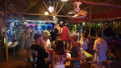 a group of people standing around in a party at iHome Backpacker Resort in Mui Ne