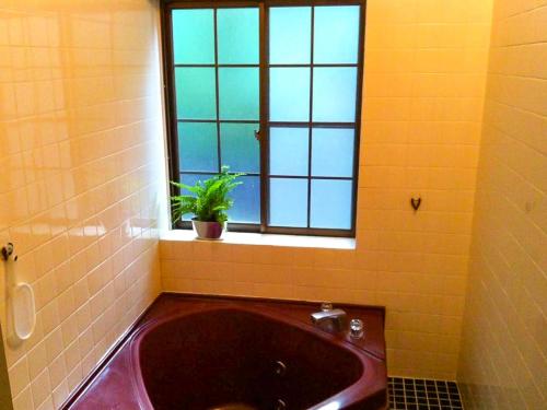 a bathroom with a large tub and a window at Pension Wildflowers in Tateshina