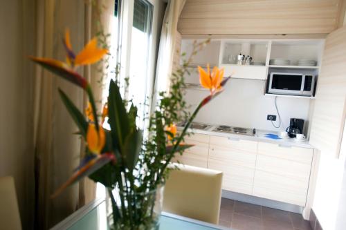 a vase of flowers sitting on a table in a kitchen at Excelsior Hotel E Appartamenti in Loano