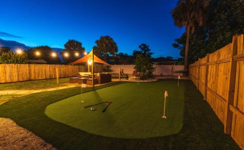 a putting green with golf balls and clubs on it at Golfers Paradise 4-hole PUTT-PUTT, Mega Chess with huge backyard, hammock in Jupiter