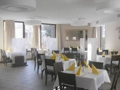 a restaurant with tables and chairs with yellow napkins on them at Hotel Restaurant Sonne-Post in Murrhardt