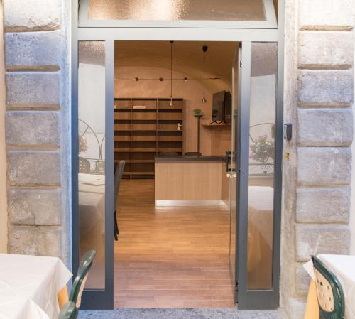 una porta a vetri che conduce a una camera con tavolo di il Caravaggio b&b a Caprarola