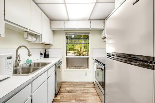 a kitchen with white cabinets and a sink at The Lakefront Treehouse in Shelton