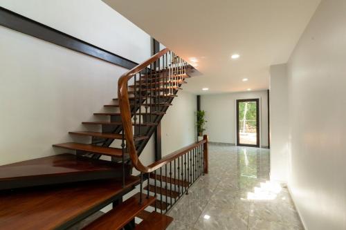 a wooden spiral staircase in a house at Cung Mây Villas - Venue Travel in Ba Vì