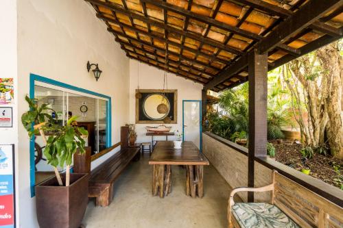 a dining room with a wooden table and benches at Hotel Miratlantico Búzios in Búzios