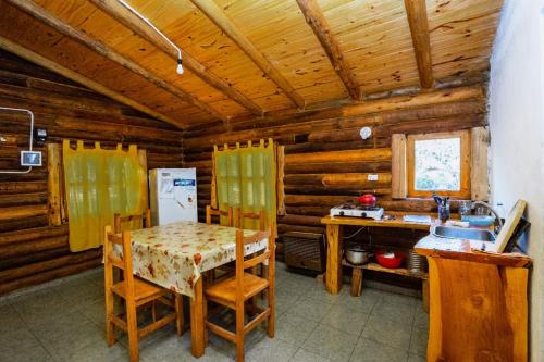 a kitchen with a table and chairs in a cabin at Posada Arco Iris in San Marcos Sierras