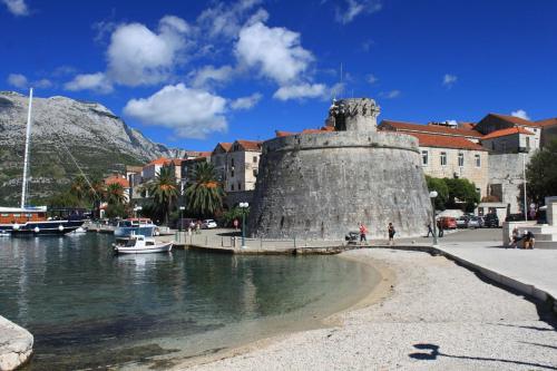 a group of boats in a body of water with buildings at Apartments by the sea Korcula - 10054 in Korčula