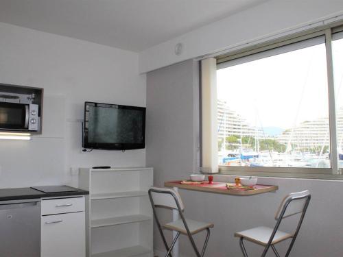 une cuisine avec deux chaises, une table et une fenêtre dans l'établissement Studio Coquet 150m Plage, Villeneuve-Loubet - FR-1-252A-86, à Villeneuve-Loubet