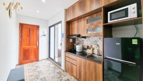 a kitchen with a black refrigerator and a microwave at VNAHOMES Serviced Apartment in Hanoi