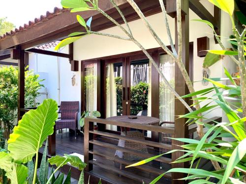 a wooden deck with a table and chairs on a house at The Yoga Garden in Gili Trawangan