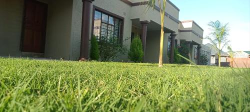 a house with a field of grass in front of it at Macb Estate - Apartments in Chililabombwe in Chililabombwe