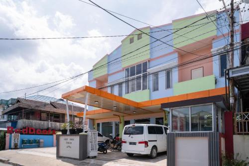 a colorful building with a white van parked in front at RedDoorz Syariah near Taman Siring 2 in Benuaanyar