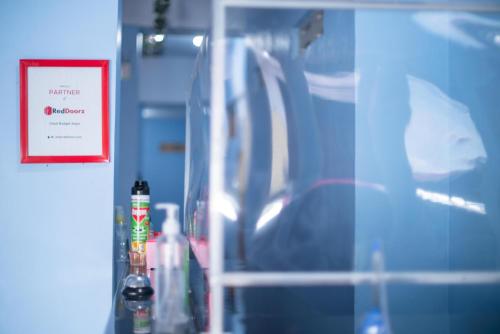 a shelf in a room with bottles and a red sign at RedDoorz Syariah near Taman Siring 2 in Benuaanyar