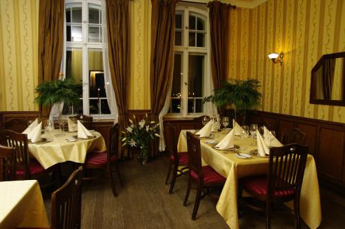 restauracja z dwoma stołami i krzesłami z serwetkami w obiekcie Pensjonat - Restauracja Żółty Domek w Szczecinku