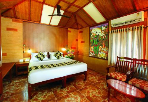 a bedroom with a bed and a desk in a room at Cherai Beach Resorts in Cherai Beach