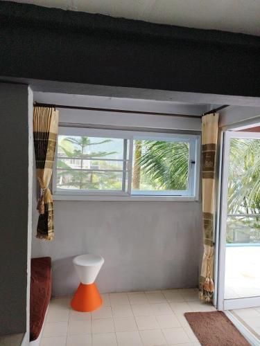 a living room with a window and a white table at Thanorm Rak Resort in Khao Kho