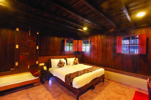 a bedroom with a bed in a room with wooden walls at Cherai Beach Resorts in Cherai Beach