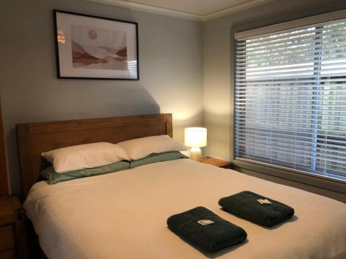 a bedroom with a bed with two towels on it at Seahorse Coastal Villas in Peterborough