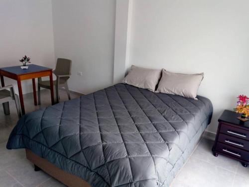 1 dormitorio con cama, mesa y mesa en Agradable casa para alojamiento completo CURITI, en Curití