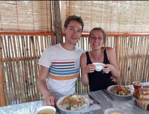a man and a woman sitting at a table with food at Nurgul in Bokonbayevo