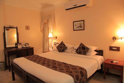 a hotel room with a large bed and a mirror at Cherai Beach Resorts in Cherai Beach