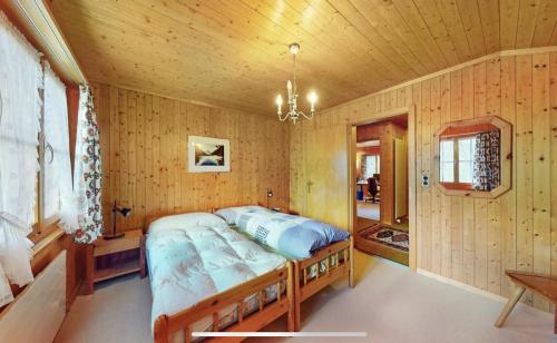 a bedroom with a bed in a wooden room at Chalet Finkenwiese in Zweisimmen