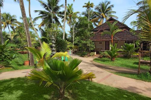 a path leading to a resort with palm trees at Cherai Beach Resorts in Cherai Beach