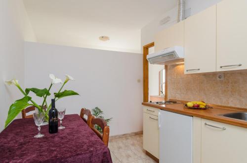 eine Küche mit einem Tisch und Weingläsern darauf in der Unterkunft Apartments with a parking space Orebic, Peljesac - 643 in Orebić