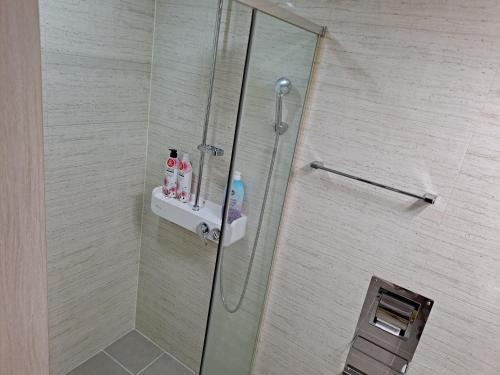 a shower with a glass shower door with a shower at Gimcheon Gumi KTX Yulgokdong Apartment in Gimcheon
