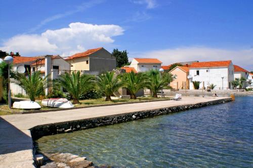 a canal with houses and buildings next to a city at Apartments by the sea Drace, Peljesac - 14019 in Janjina