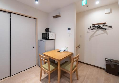 a small kitchen with a table and a refrigerator at HANASTAY花渓居 · 丘（OKA) in Osaka
