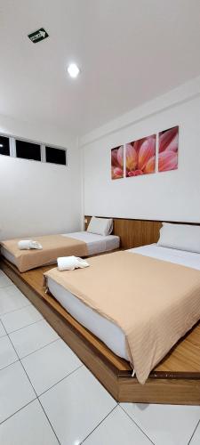 two beds in a hotel room with two at Api-Api GuestHouse in Kota Kinabalu