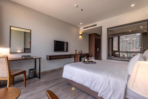 a hotel room with a large bed and a television at Reyna Hotel Hanoi & Spa in Hanoi