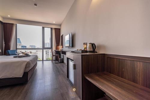 a hotel room with a bed and a large window at Reyna Hotel Hanoi & Spa in Hanoi