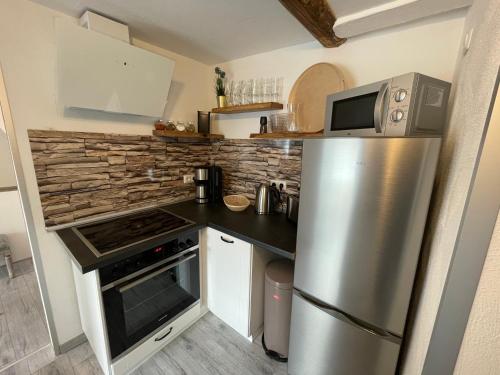 a kitchen with a stainless steel refrigerator and a microwave at Ferienwohnung Goslar am Marktplatz A4 in Goslar