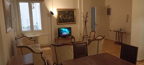 a living room with a table and a television at Amerikis Street 1 bedroom apartment in Athens