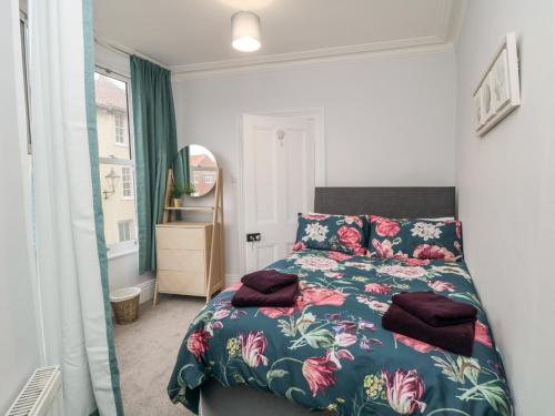 ein Schlafzimmer mit einem Bett mit geblümter Tagesdecke in der Unterkunft 1 Princess Street in Scarborough
