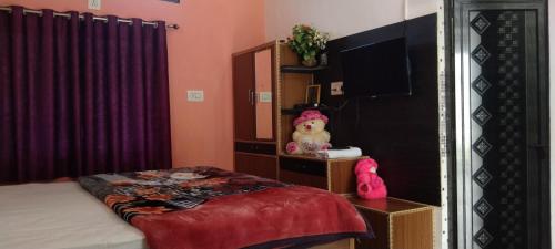 um quarto com um espelho, uma cama e uma televisão em Peaceful Home Stay em Khajurāho