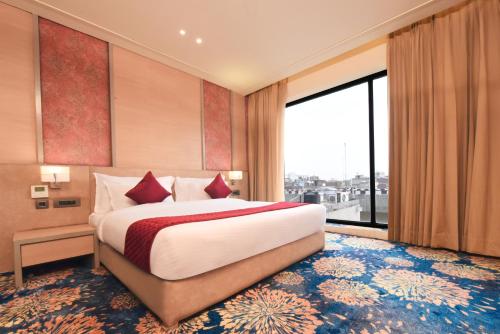 a bedroom with a large bed and a large window at The Pribson Hotel in Amritsar