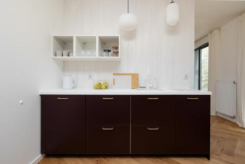 a kitchen with black cabinets and a white counter top at LoveSea apartments Rewal in Rewal