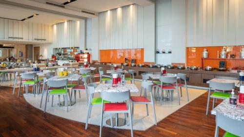 a room with tables and chairs and a kitchen at ibis New Delhi Aerocity - An Accor Brand in New Delhi