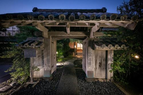 唐津的住宿－美津濃旅館，通往带石拱门的花园的入口
