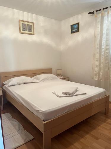 a bedroom with a bed with white sheets and a window at Apartments by the sea Racisce - Korcula - 4359 in Račišće