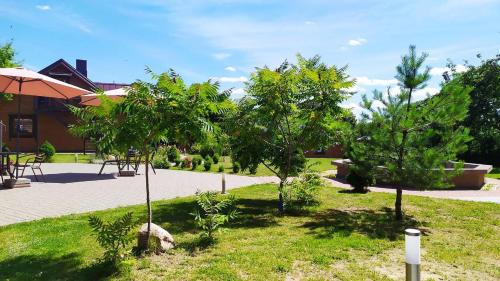 a garden with trees in front of a building at "Trakaitis" apartments & holiday homes in Trakai