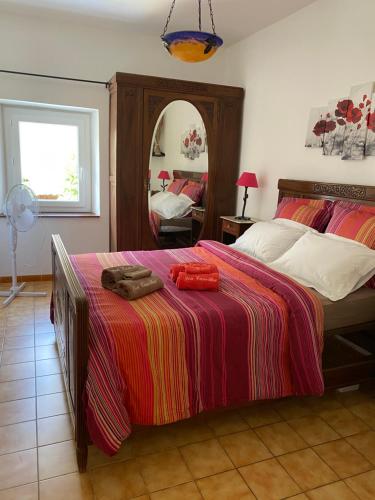 - une chambre avec un lit doté d'une couverture rouge et d'un miroir dans l'établissement Lou Camillou, à Valvignères