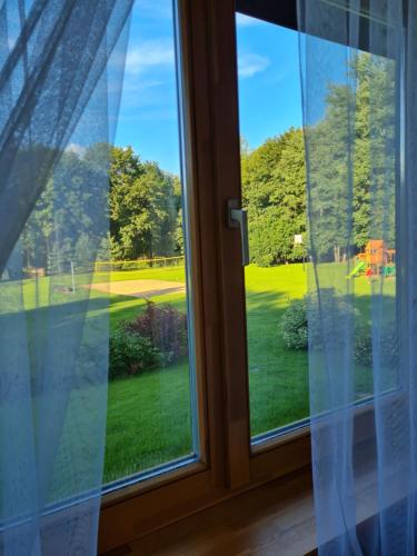 a view from a window of a golf course at Atostogų namelis-pirtis Prie upės in Anykščiai