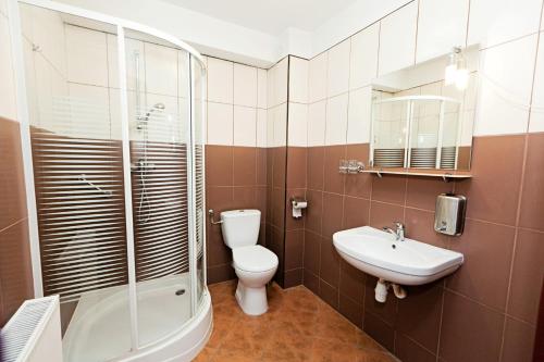 a bathroom with a toilet and a shower and a sink at Hotel Turkus in Jarosław