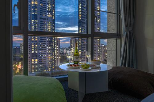 a hotel room with a table with a bottle of wine at Urbanstay Residence Dongtan in Hwaseong
