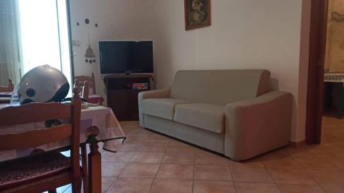 a living room with a couch and a television at Casa del Corso Ribera in Ribera