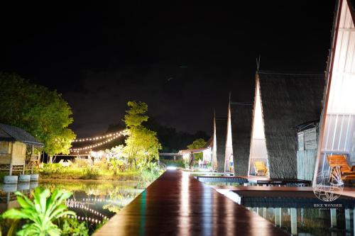 a night view of a building and a river at Rice Wonder Cafe & Eco Resort in Rayong